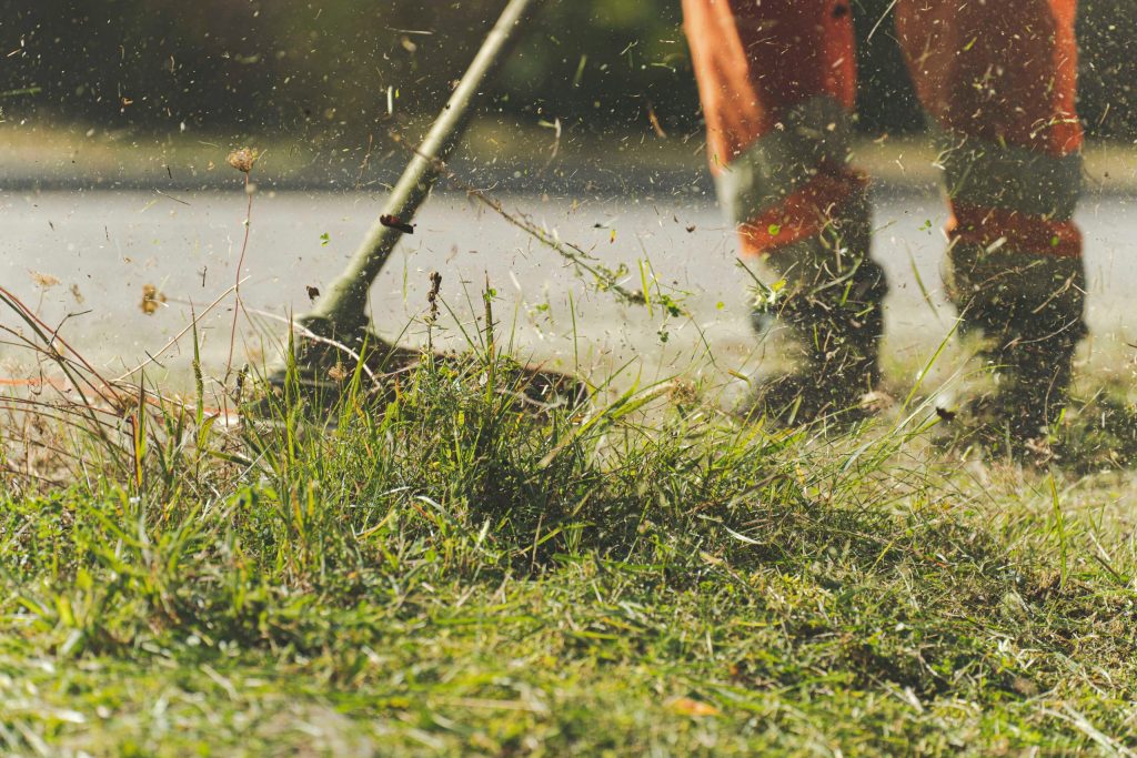 Man doing gardening and landscaping while using a mower