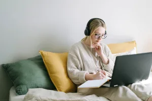 a woman listening to music while looking at her laptop